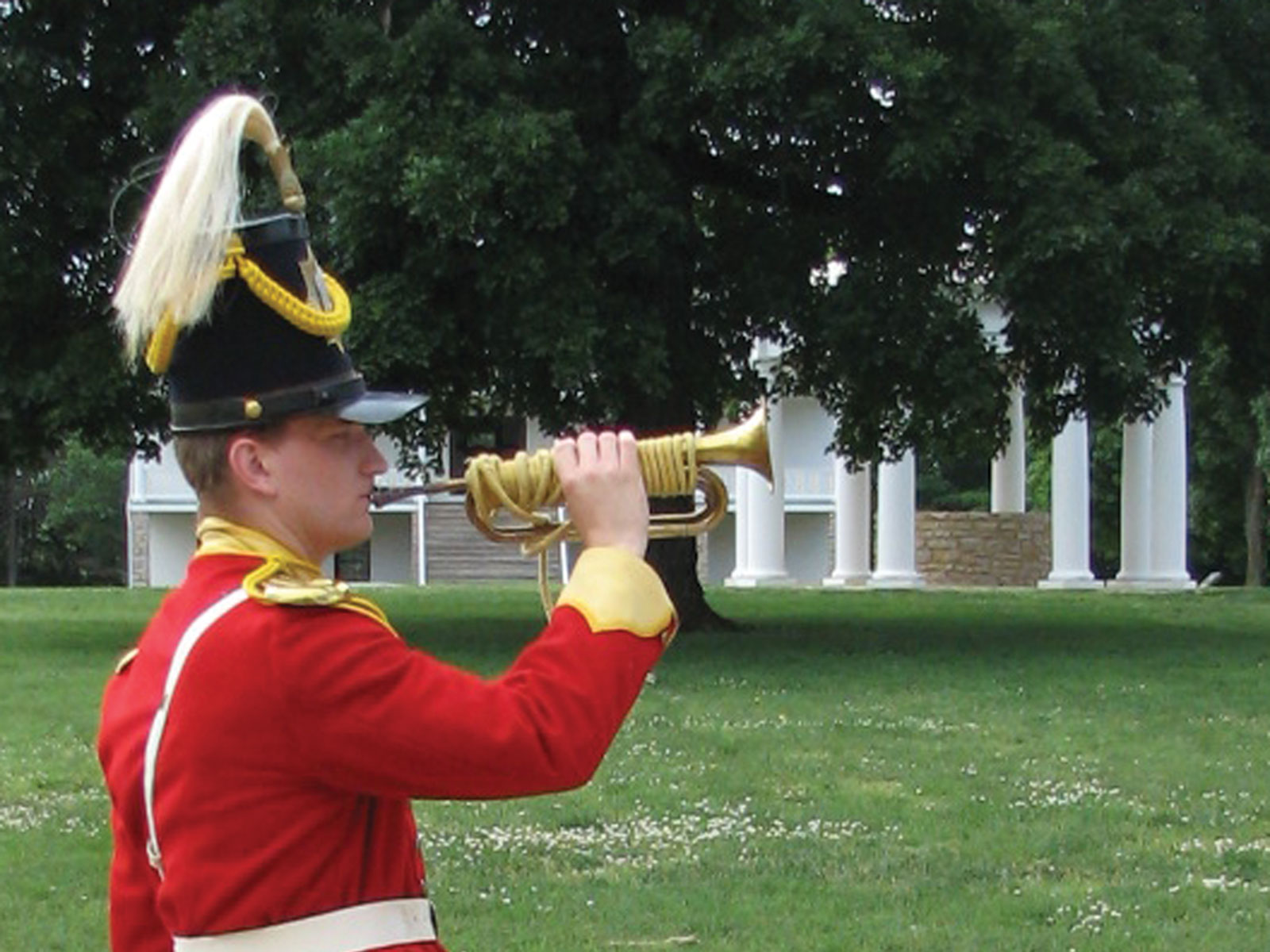 Man in red coat blowing bugle