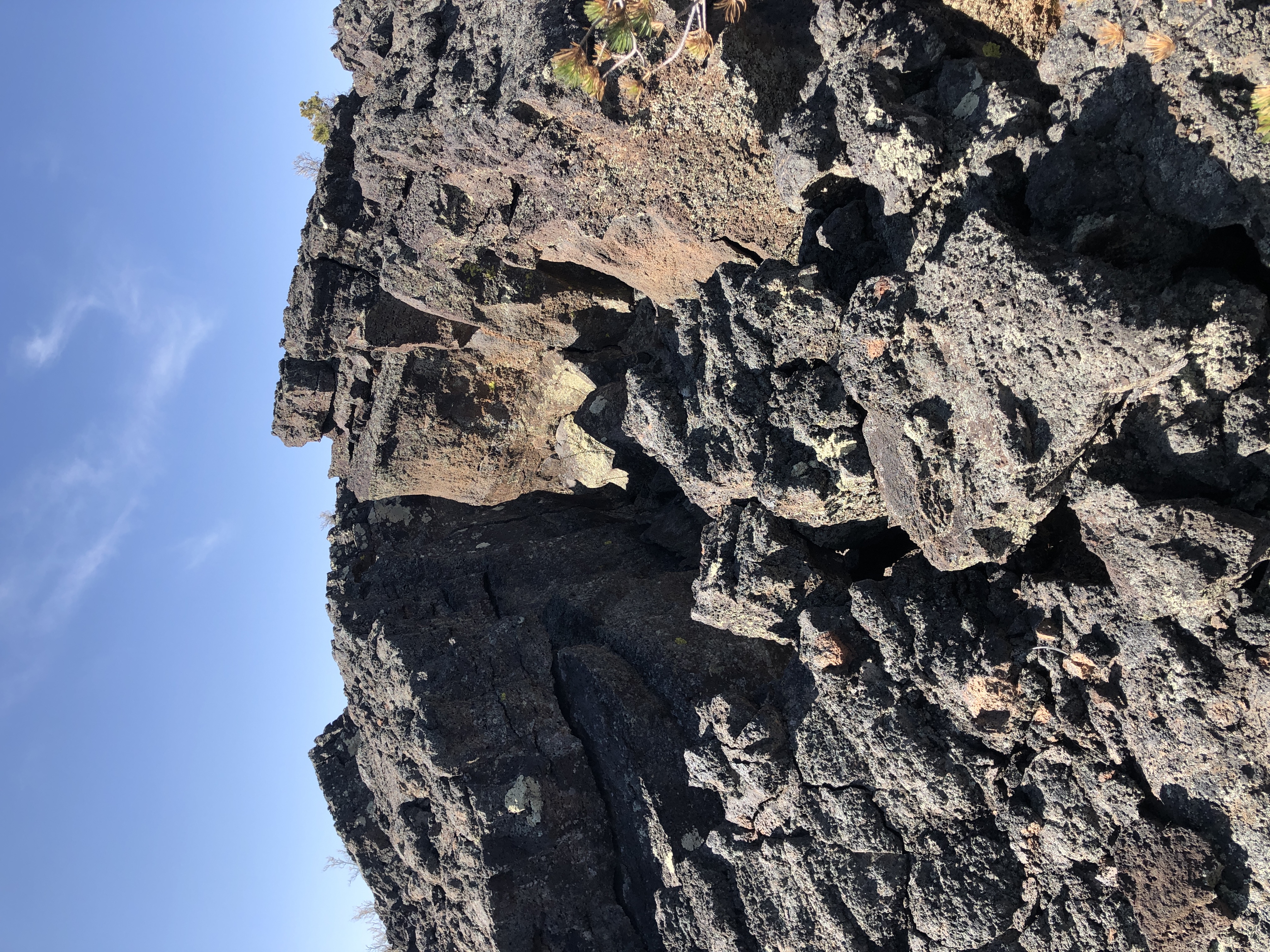 A wide and jagged crack splits two thick slabs of black lava rock directly down the middle.