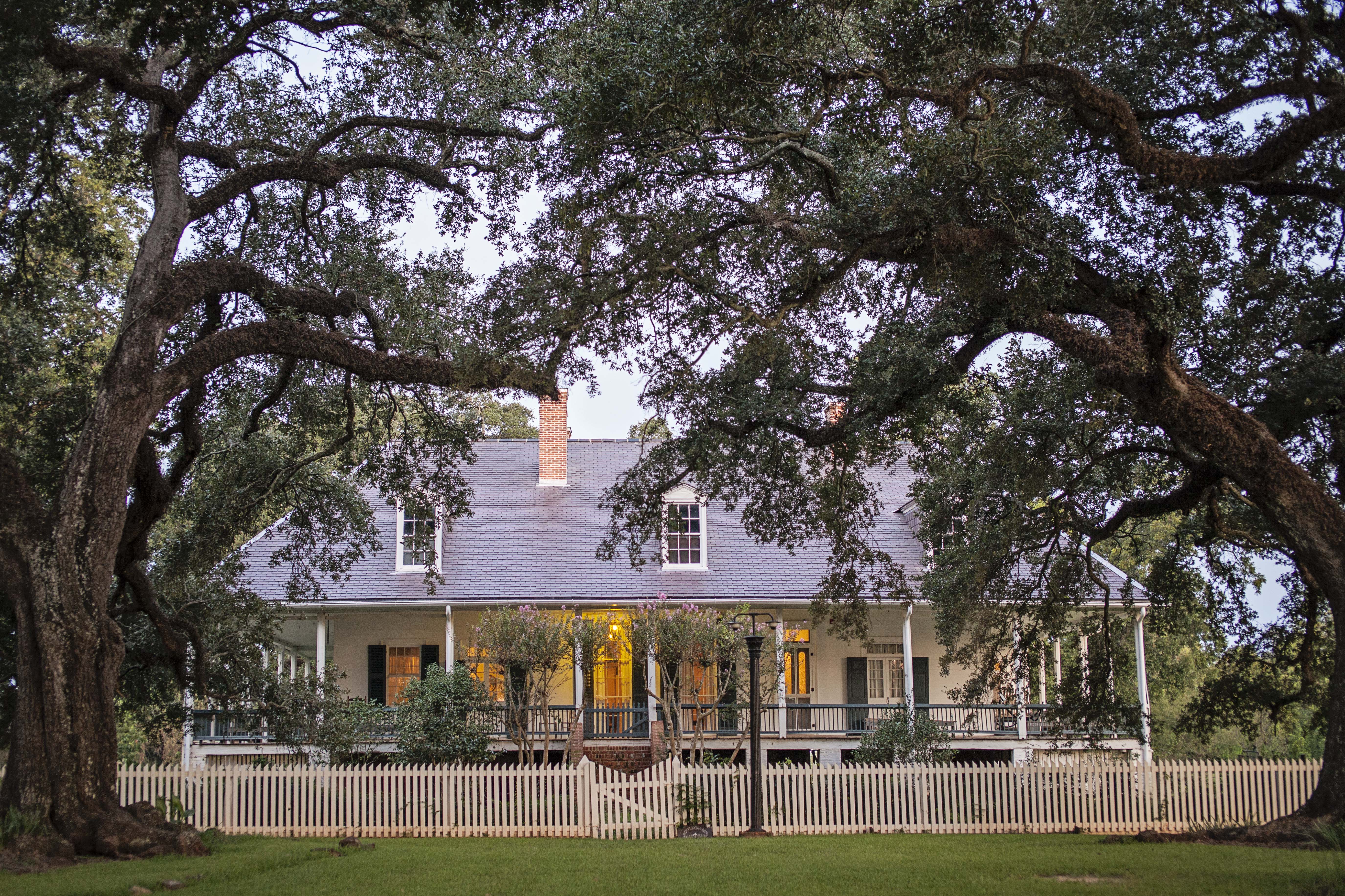 The front of the Oakland main house surrounded by trees.