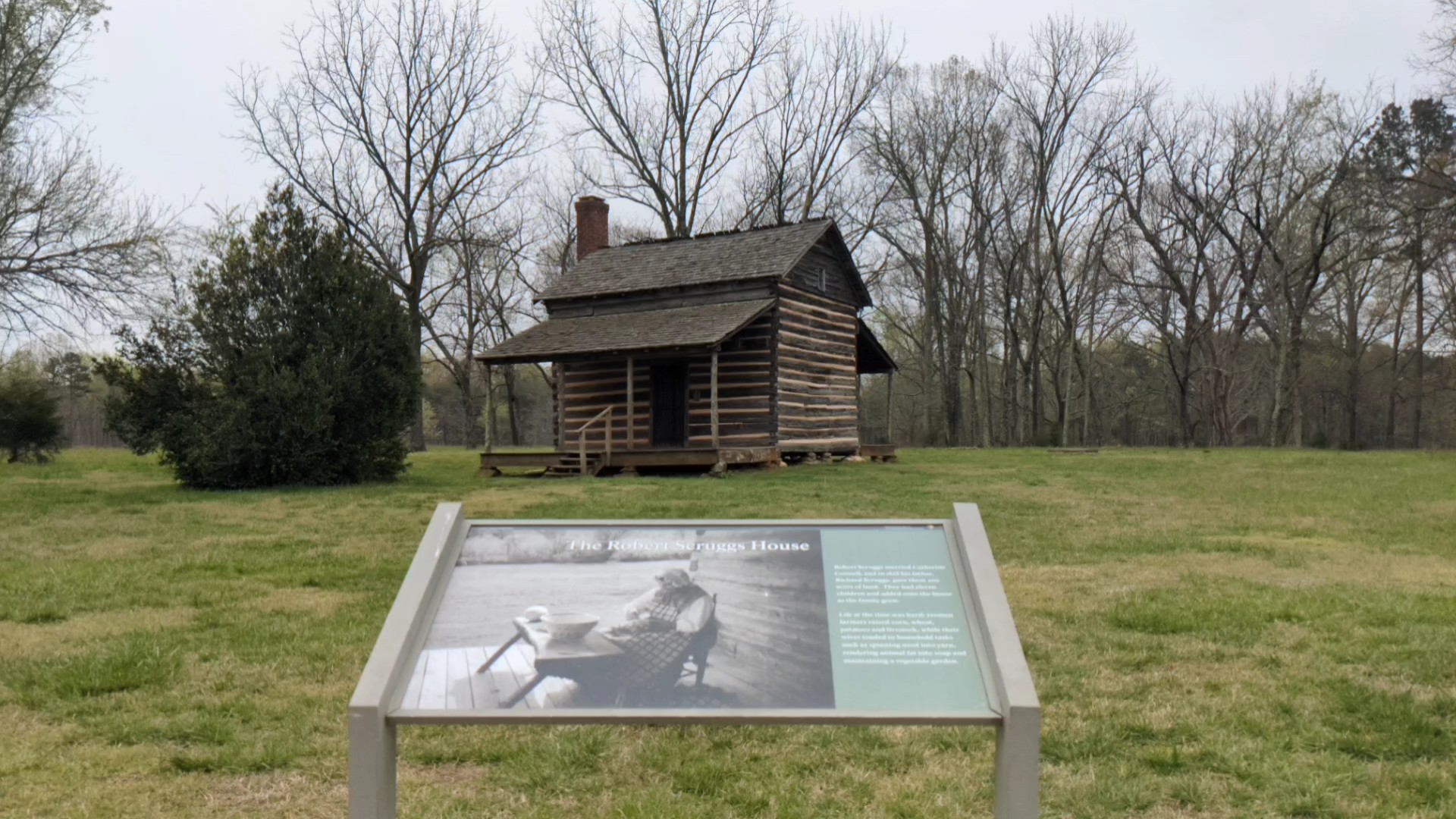 1820s log cabin in front of a way side