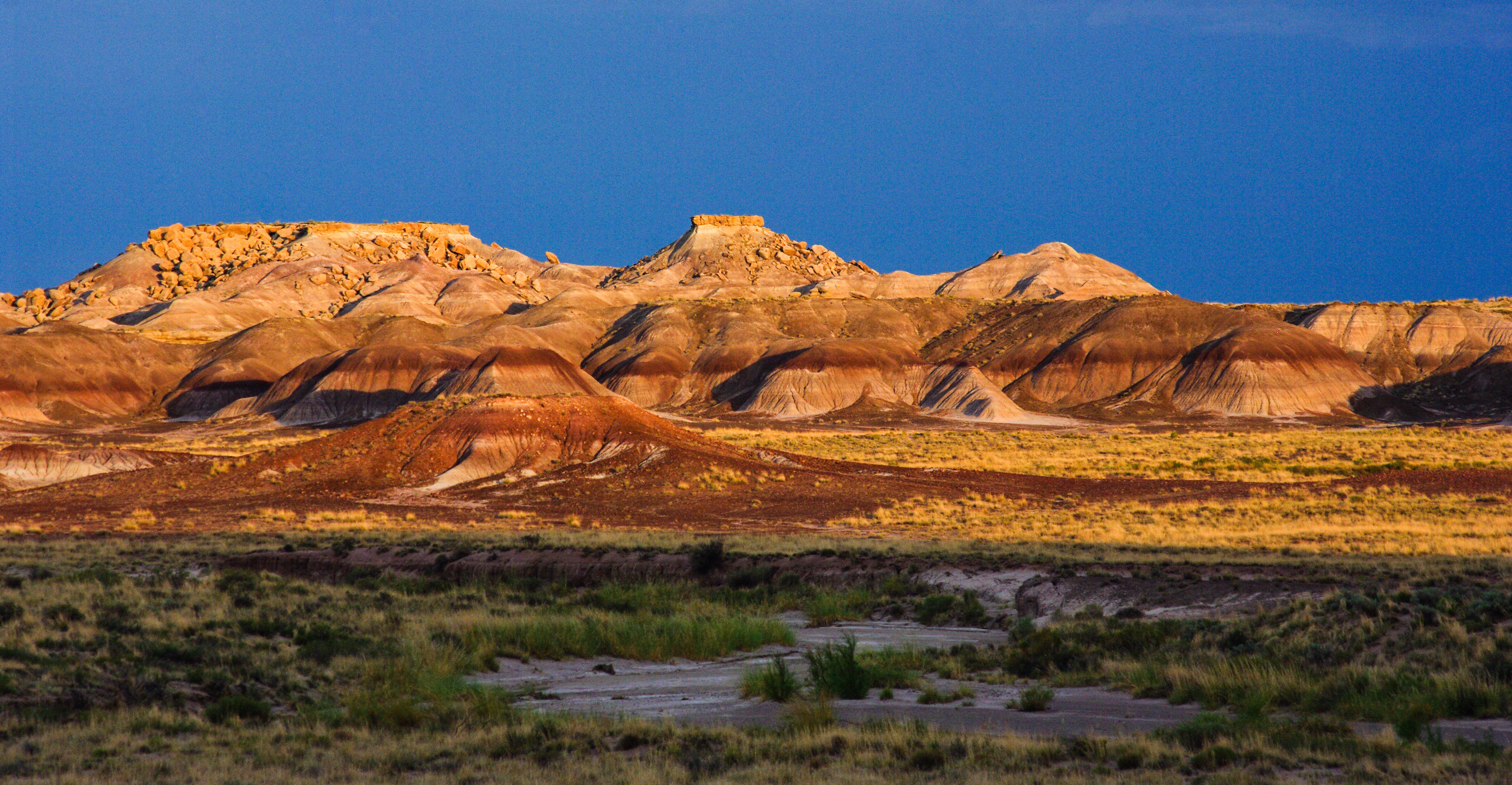 Sunlit badlands at the south end of the park under a twilight sky.