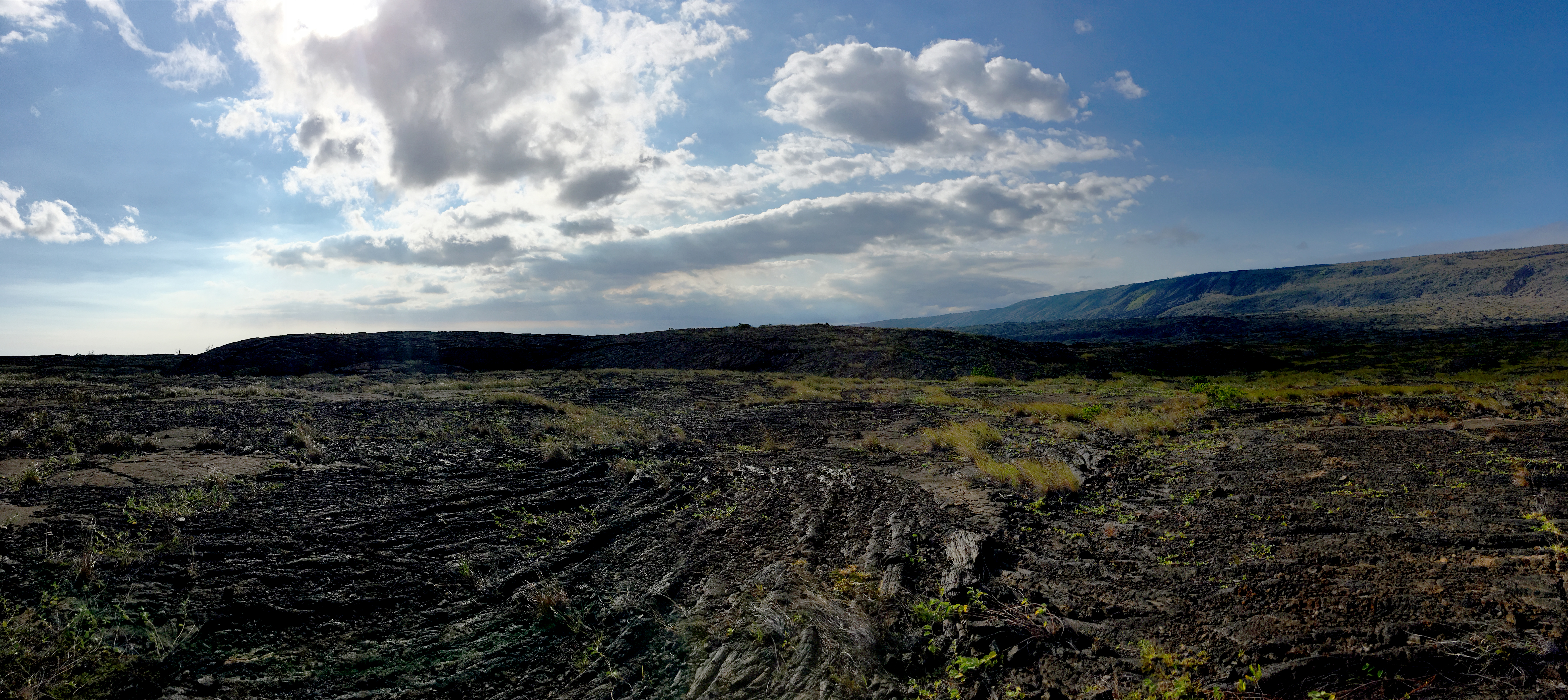 A volcanic dome in a distance surrounded by lava rock.