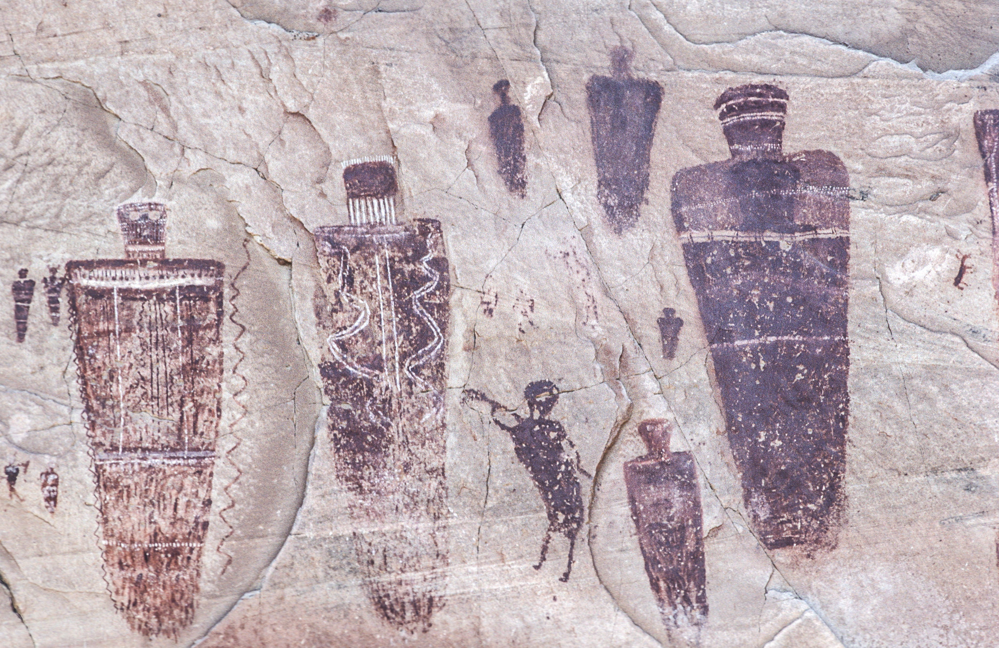 Red, brown and white figures on rock in the Grand Gallery panel, in Canyonlands.