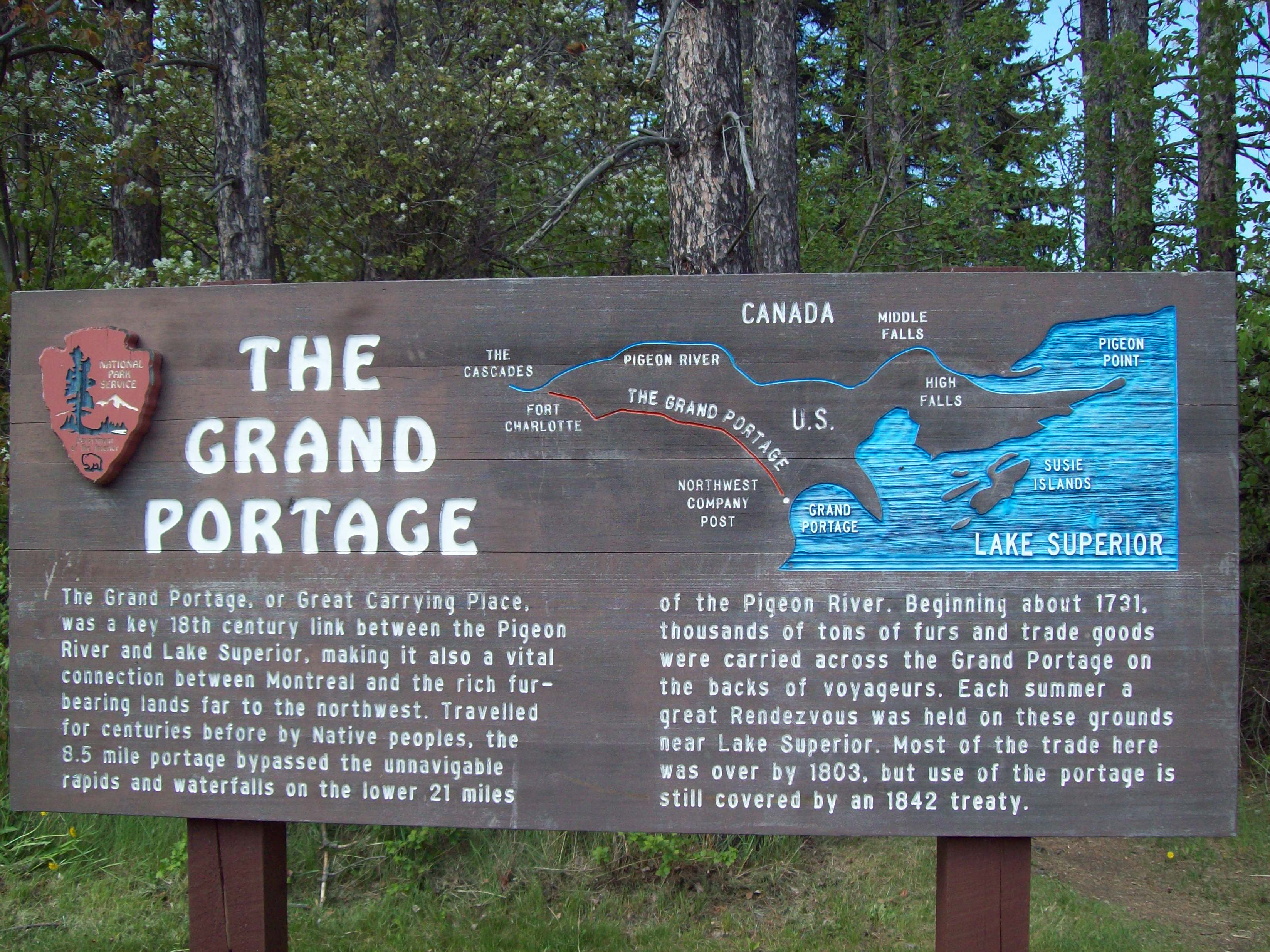 A wooden sign with interpretive text about the history of the Grand Portage Trail