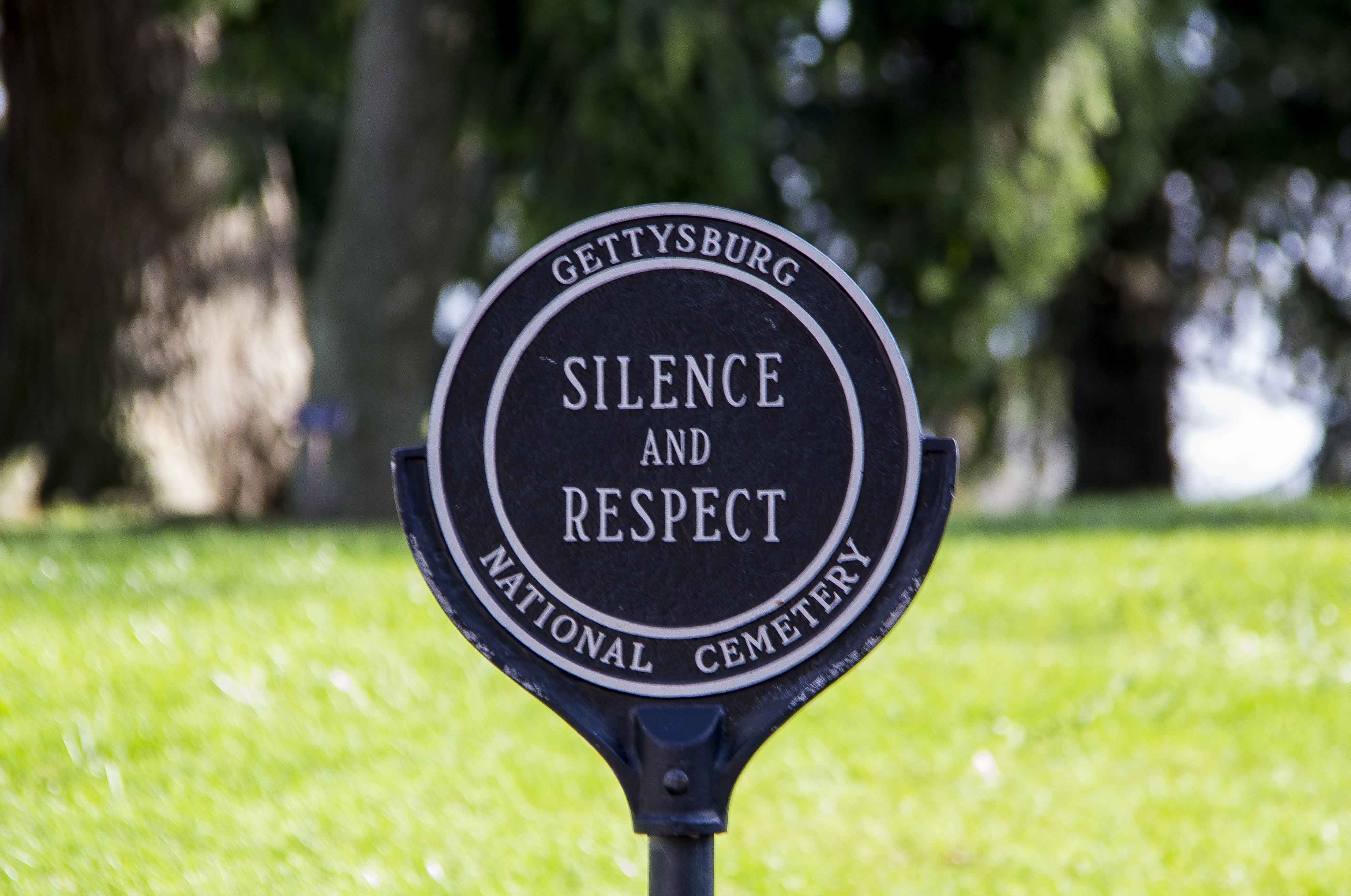 A black and white metal sign that reads "Silence and Respect"