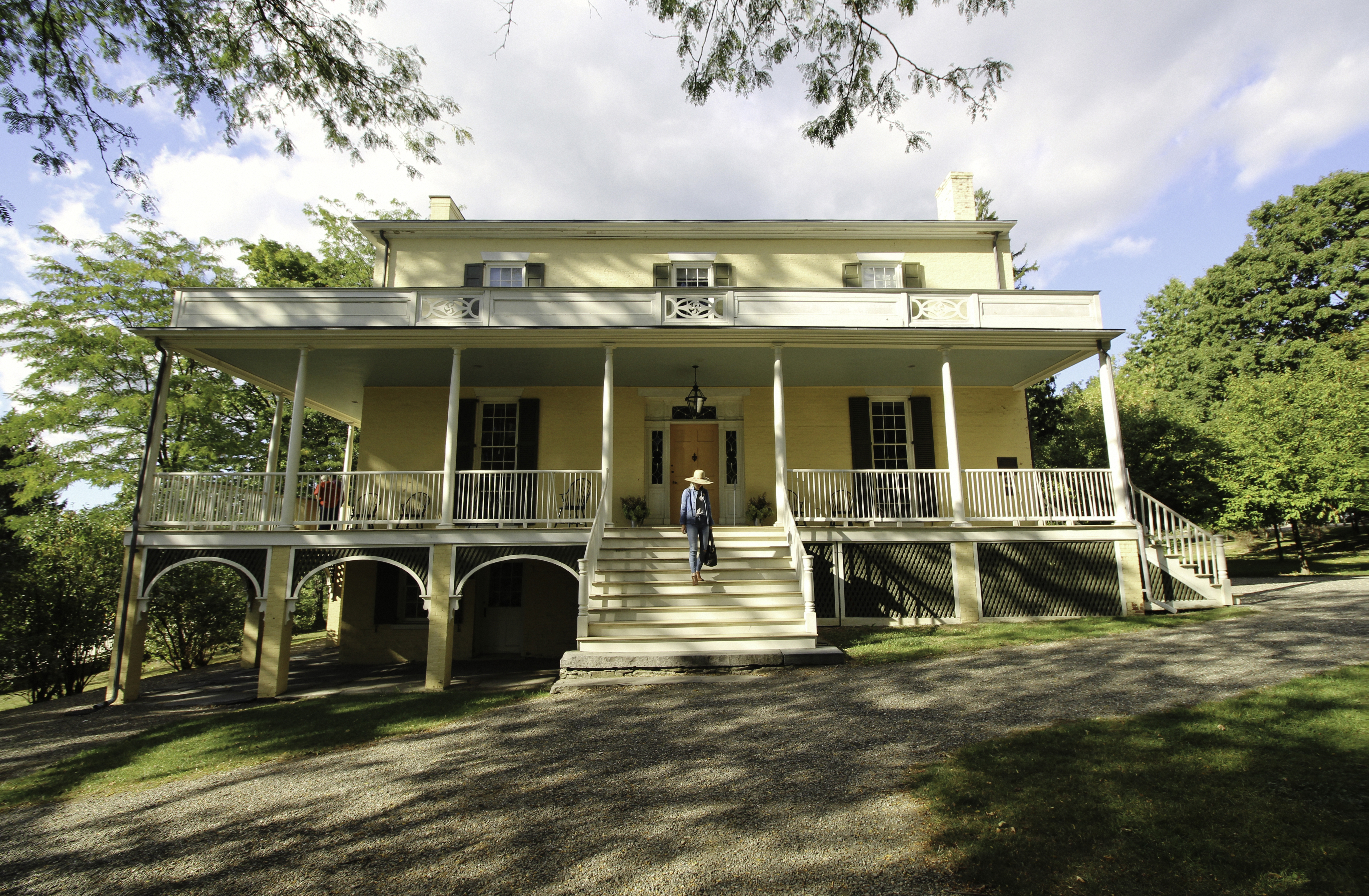 A two-story house with raised basement and large porch.
