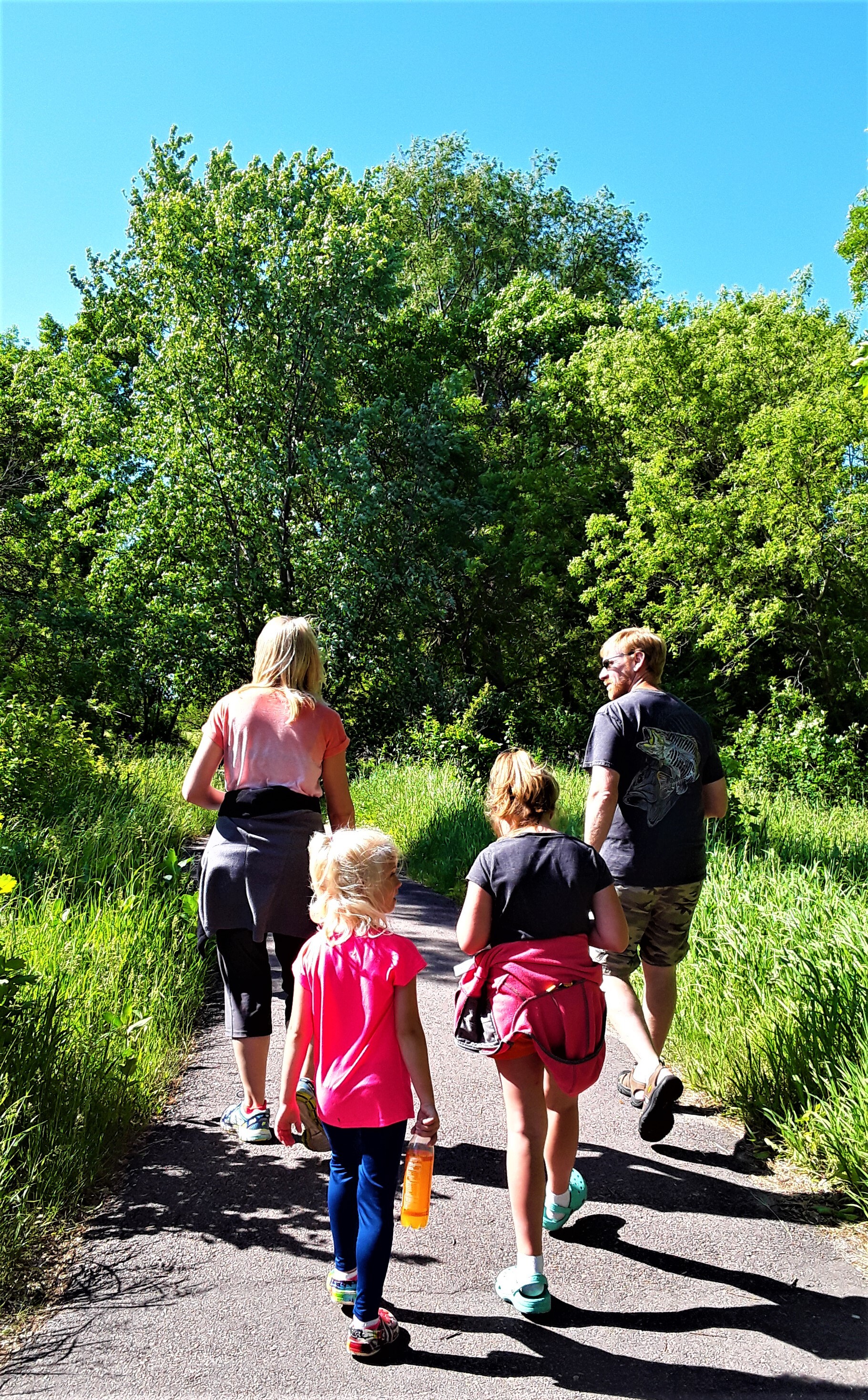 A family walking the trail on a sunny day