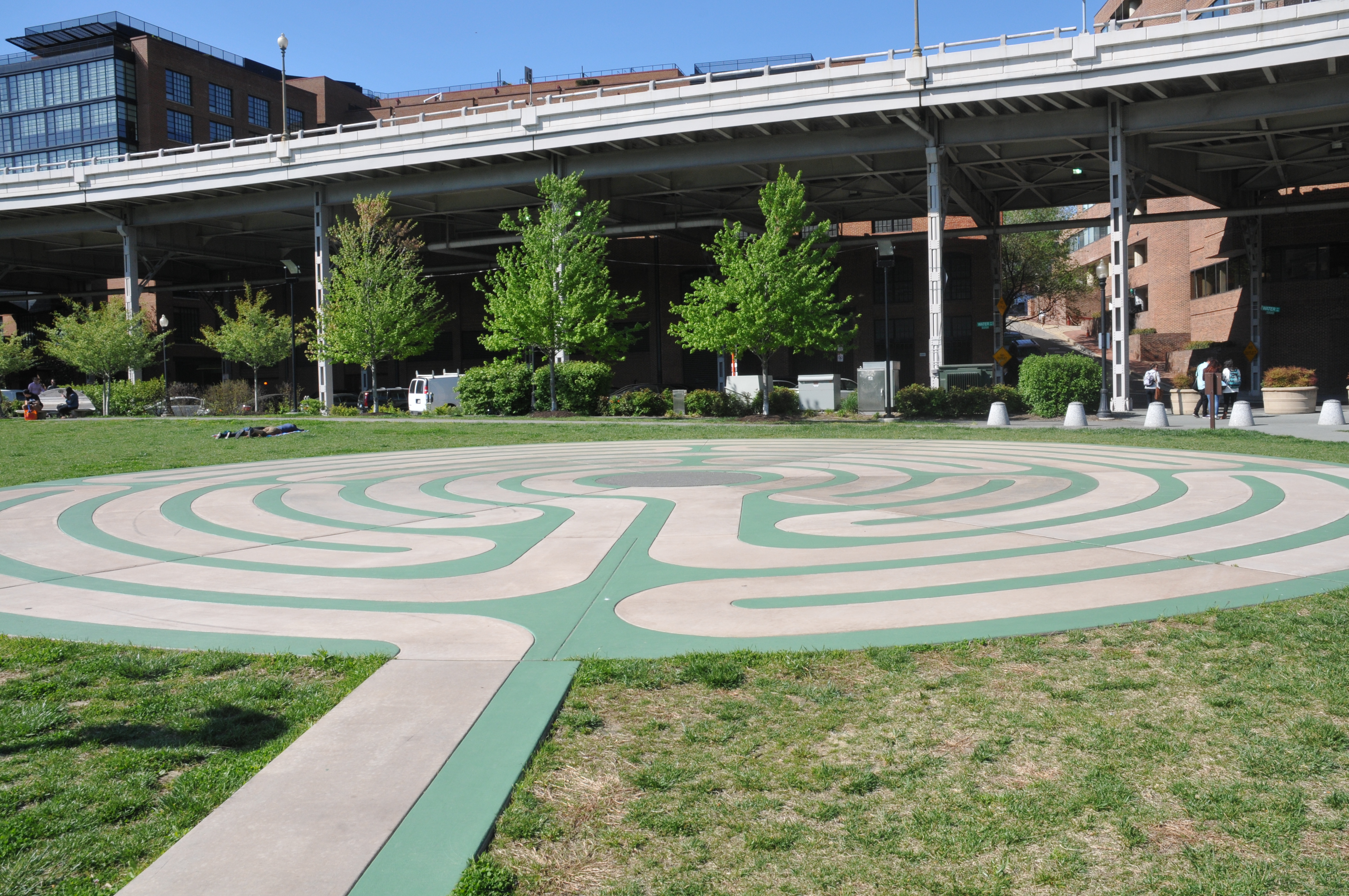 A green and gray concrete labyrinth in short green grass
