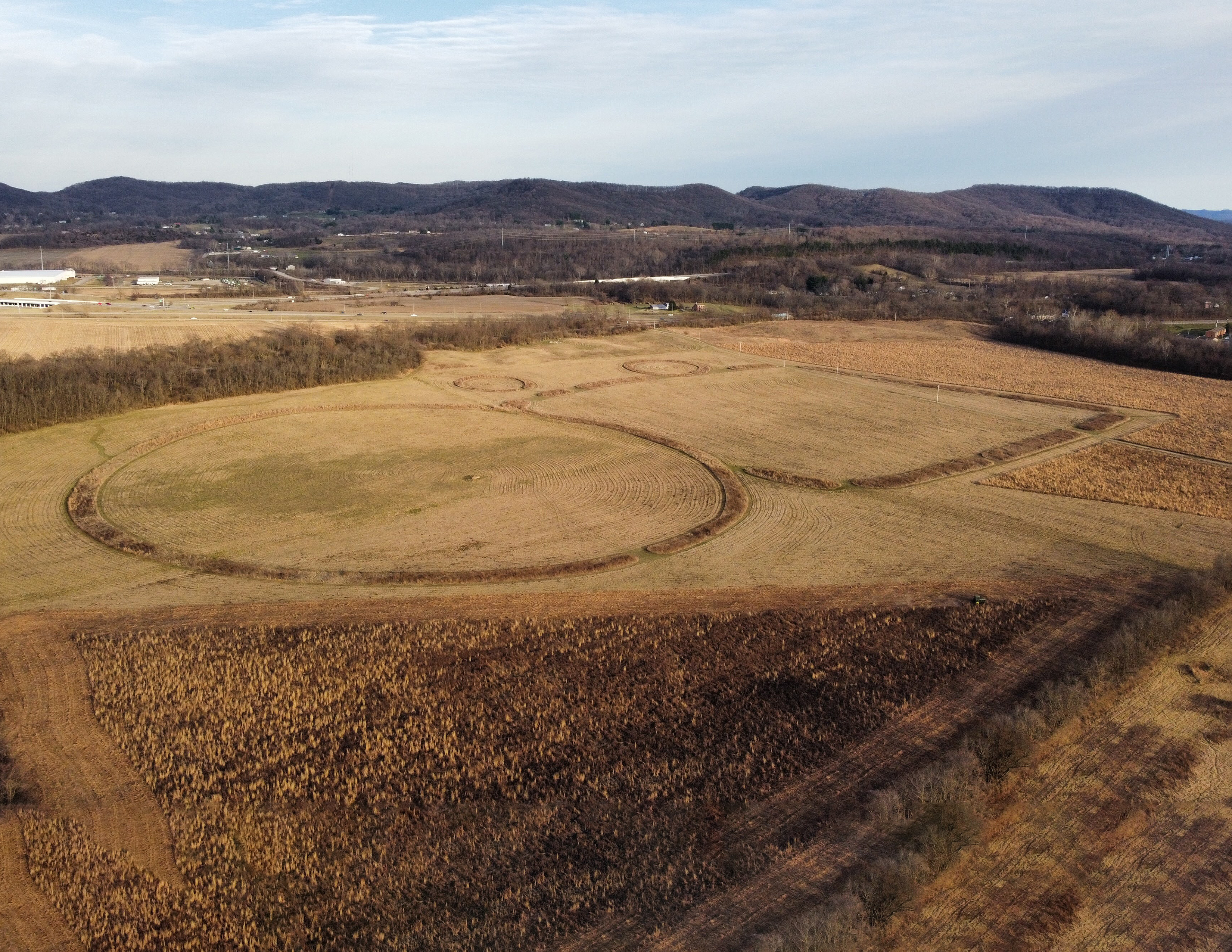 Aerial photo shows geometric earthworks.