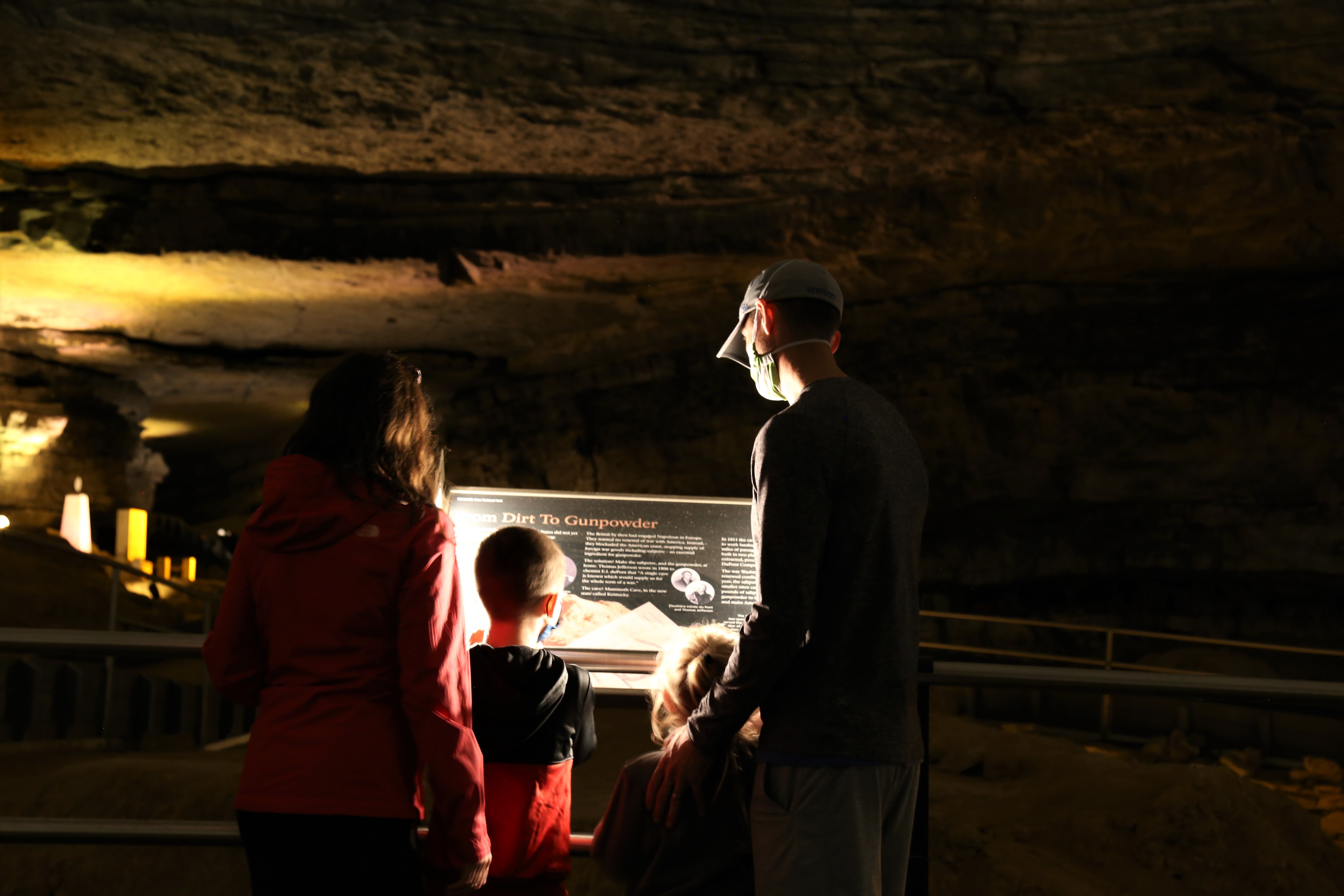 A family reads a sign inside the cave.