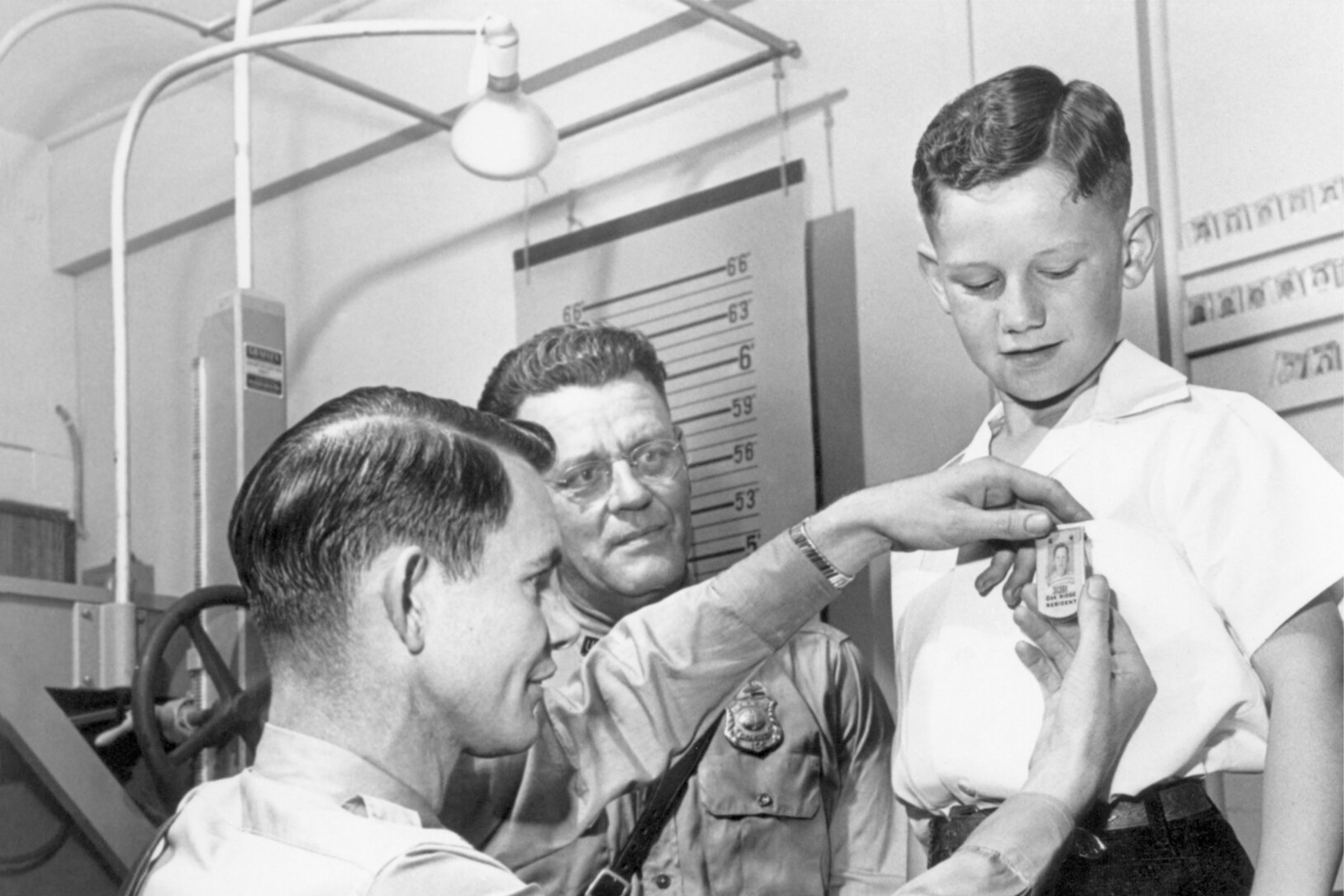 Black and white photo of child with two policemen