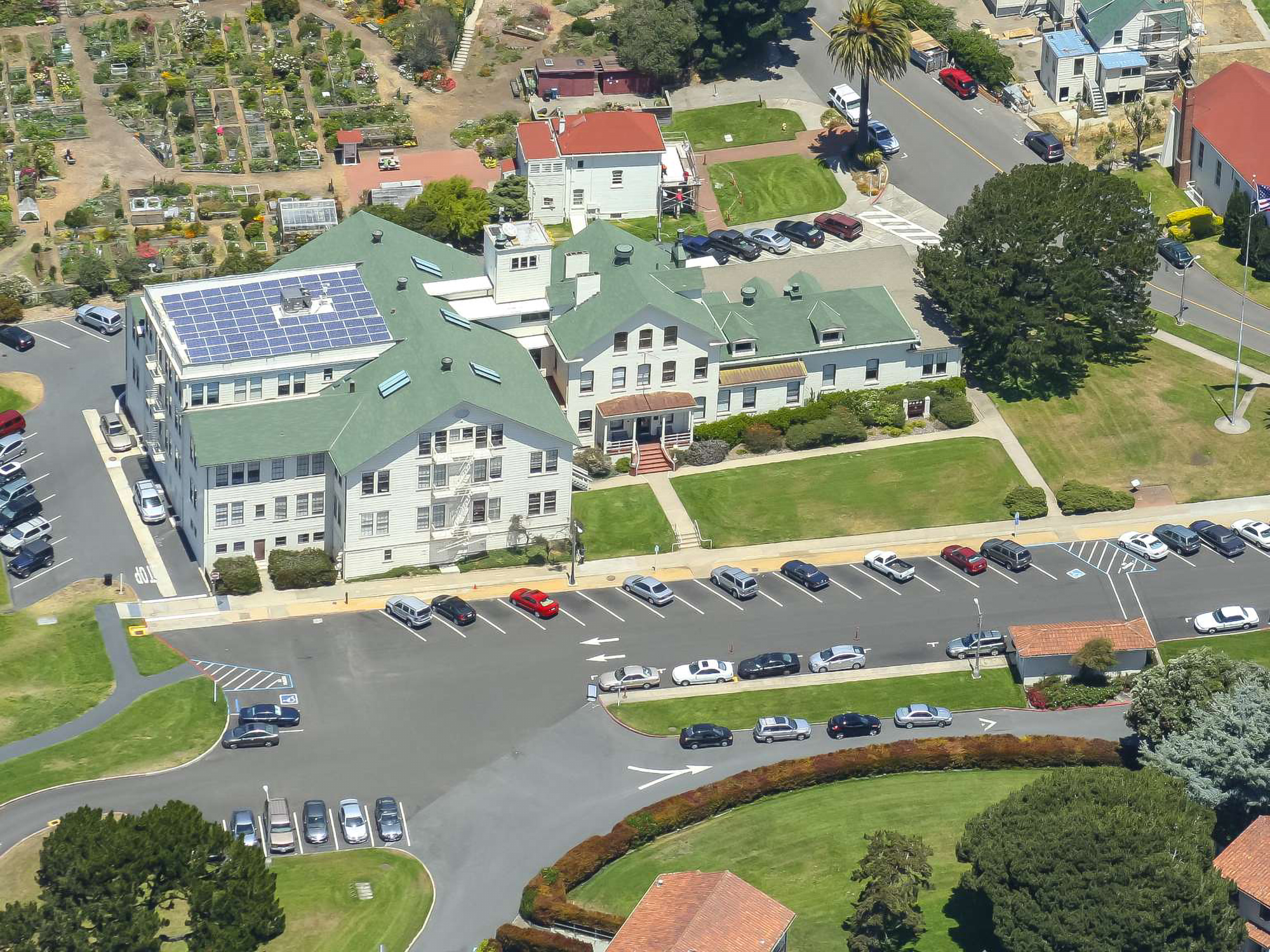 Colored aerial image of Fort Mason. Centered is a large building that is the Park Headquarters