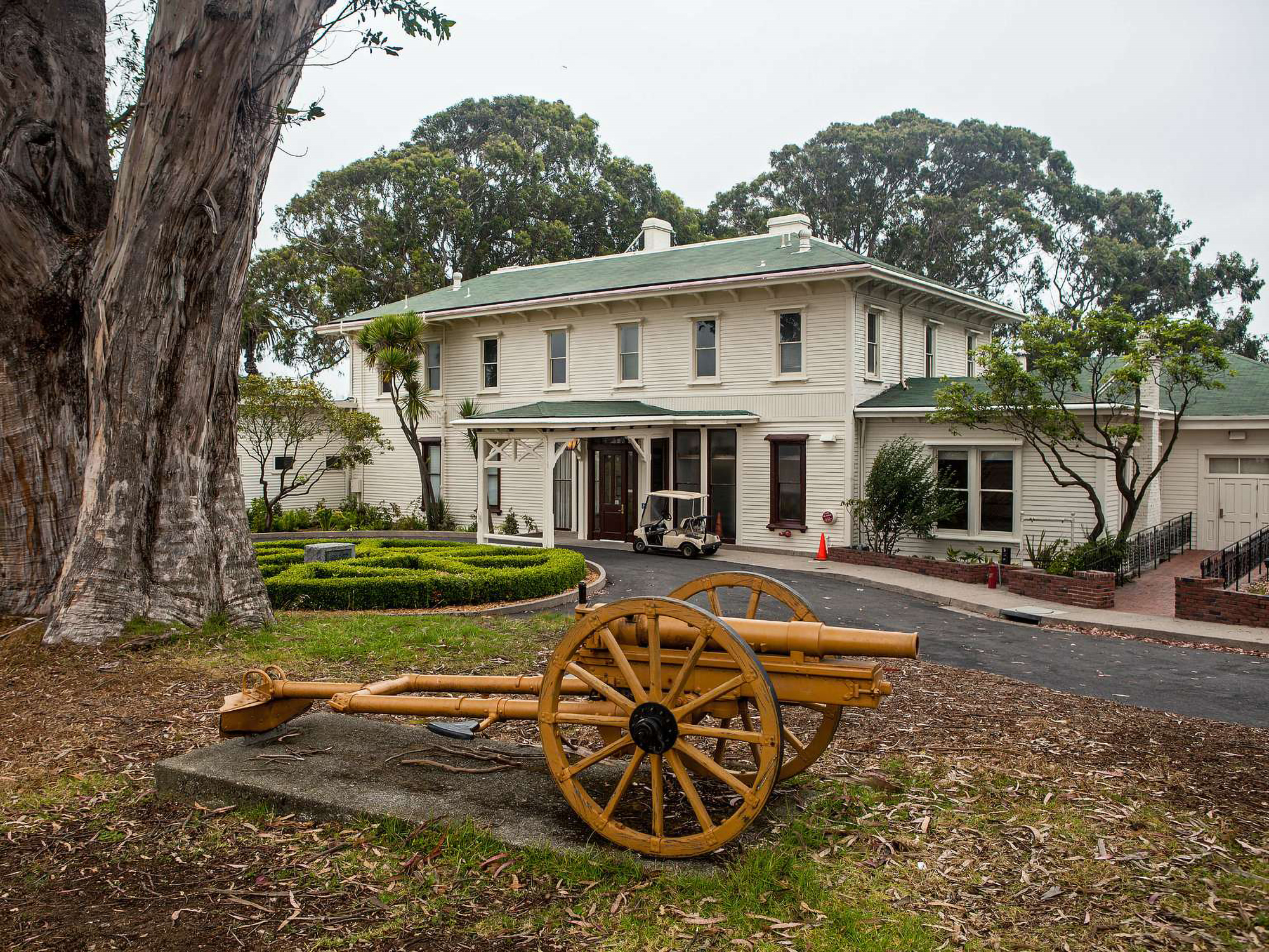 Colored photo of the entrance to the General's residence. In front is a replica of a gun on a cart.