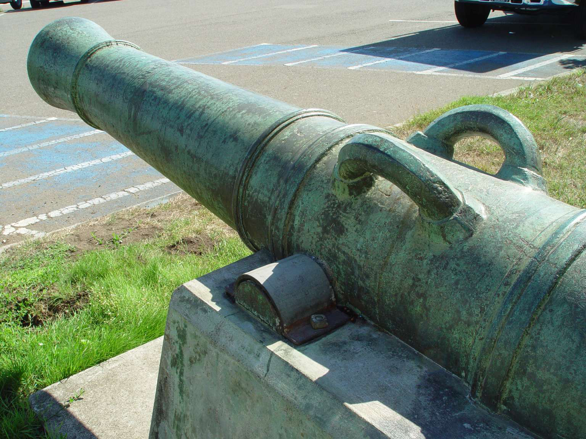 Colored photo, close up of a green patina cannon in the Presidio