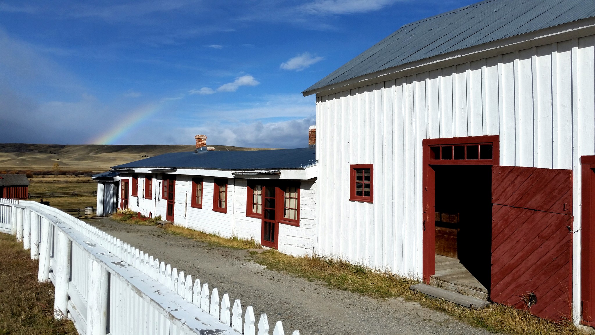 A dirt path and white picket fence run the entire length of the Grant-Kohrs Ranch bunkhouse row.