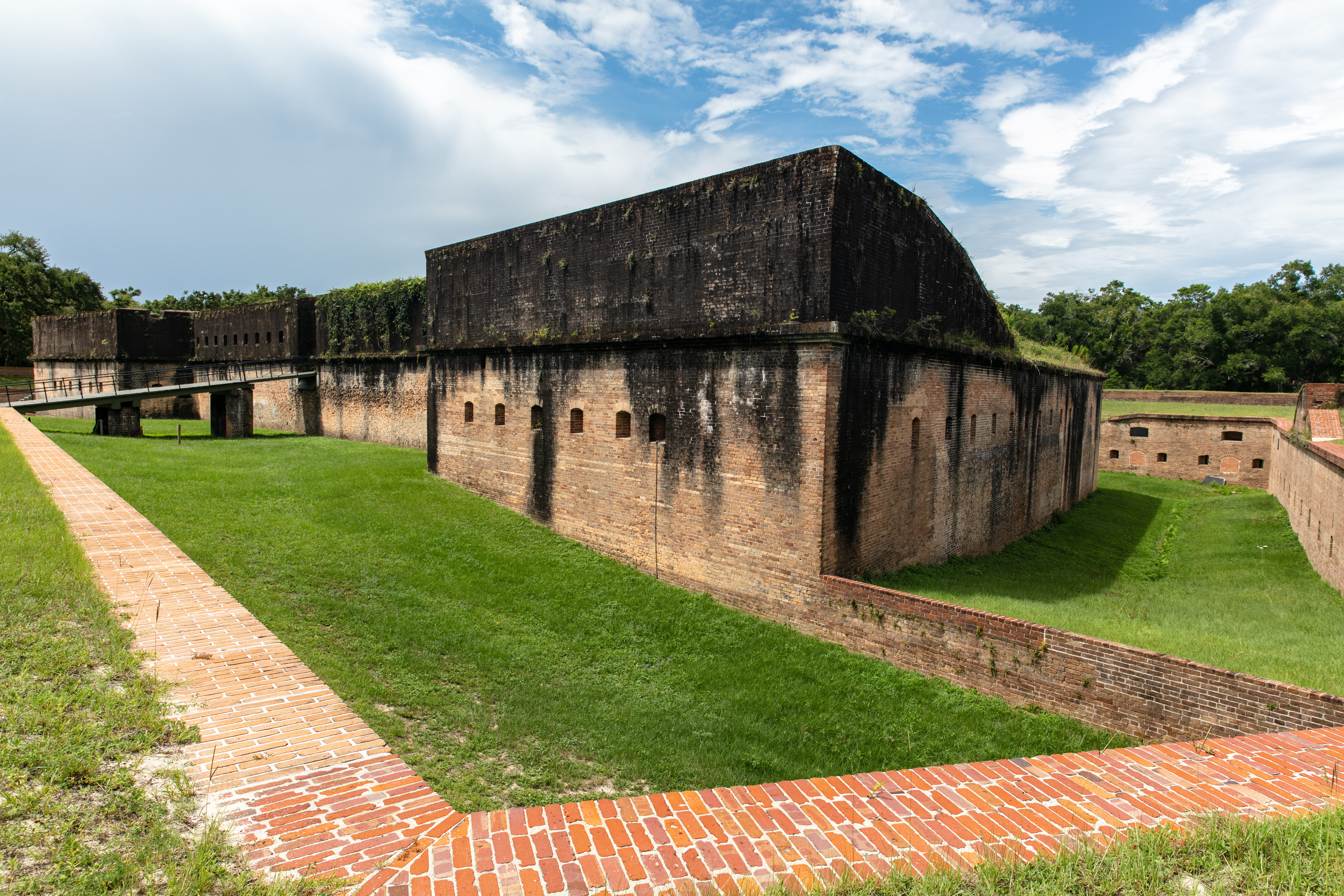 A historic Civil War era fort made of brick lies atop a grassy plain.