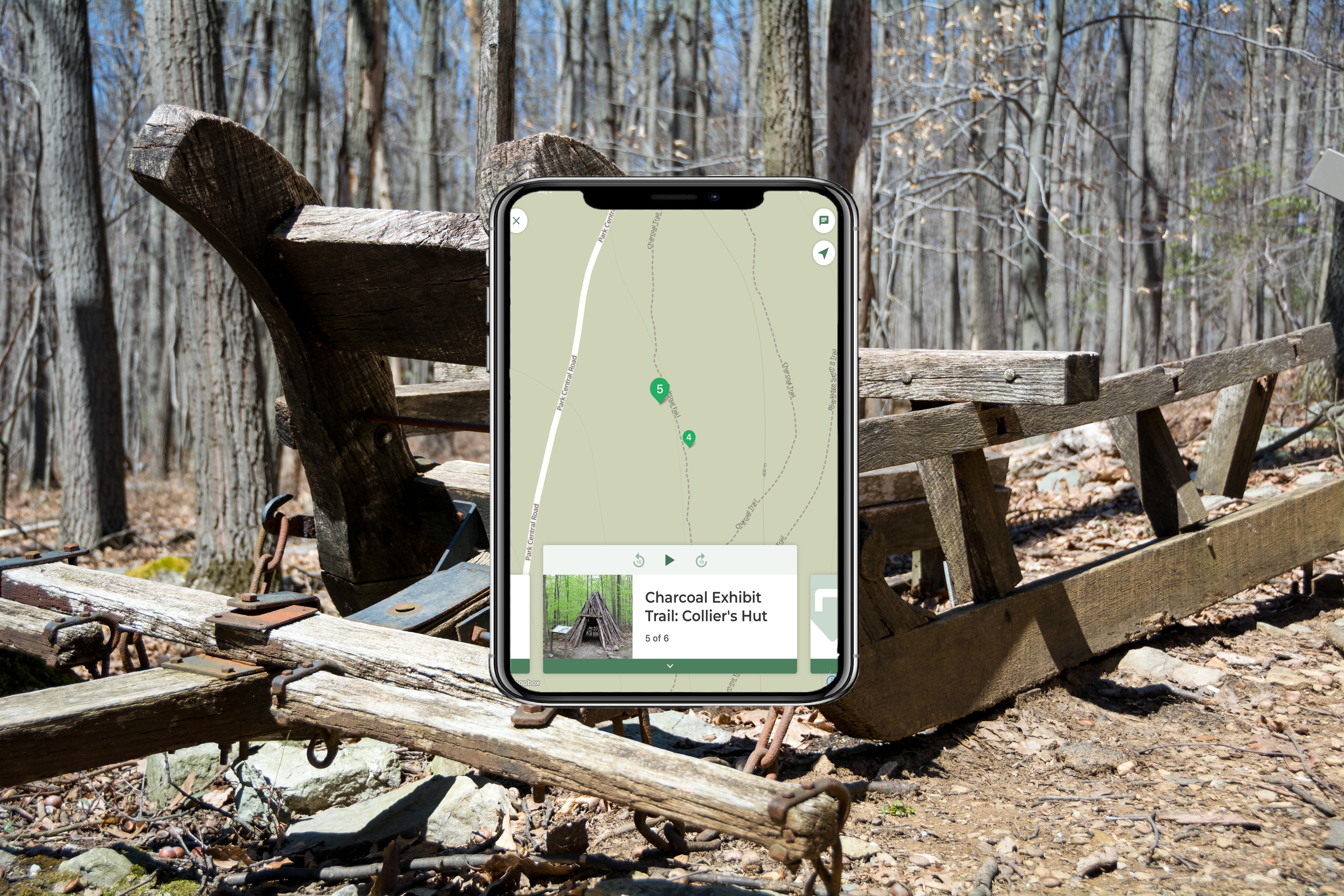 A wooden sled with a mobile device showing a map, imposed over top the image.