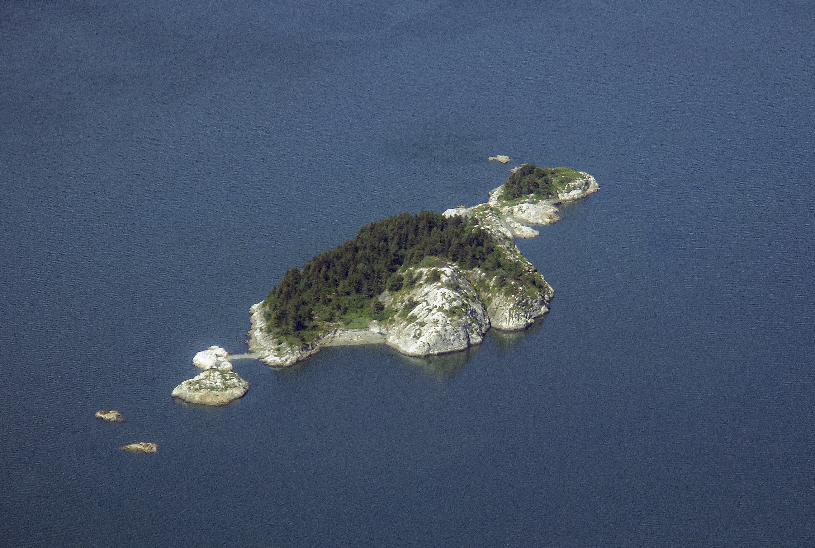 aerial view of south marble island, a rocky outcropping. Trees and green cover the higher parts.