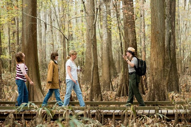 A park ranger leads a group along the Boardwalk. A park ranger leads a group along the Boardwalk.