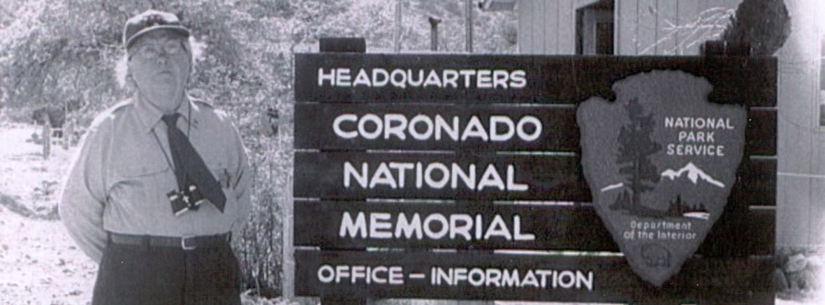 A woman in 1950s park ranger uniform next to sign