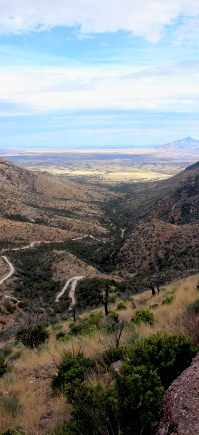 looking down on a dirt road winding up a steep canyon