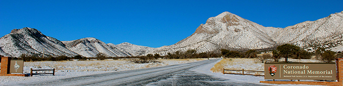 Snow covered mountains and the park welcome sign Snow covered mountains and the park welcome sign