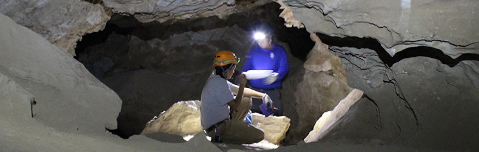 Cave scientists look at a hollow inside the cave