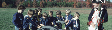 Cub Scouts and reenactor with cannon