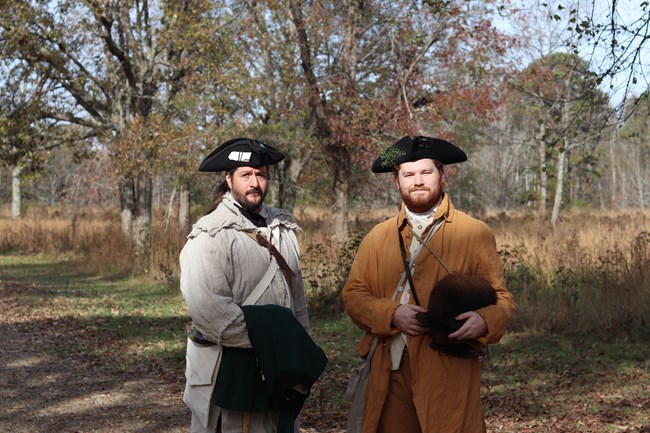 Two men in hunting frocks and tricorn hats