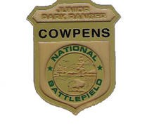 a golden badge that says, "Junior Park Ranger, Cowpens, National Park Service."
