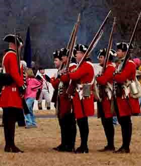 Reenactors portraying British soldiers prepare to drill.