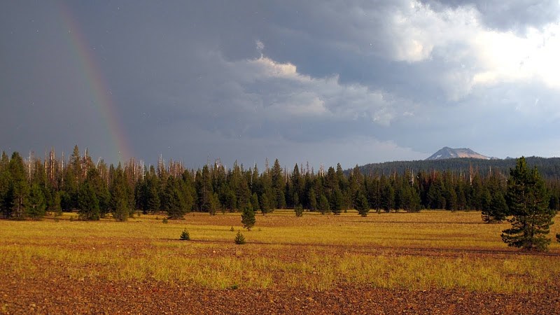 Pumice Desert with a nearby rainbow and storm clouds