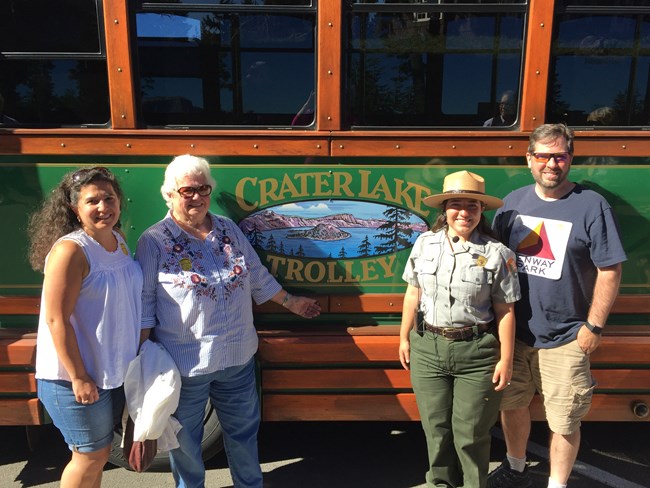 Visitors and ranger standing next to a trolley