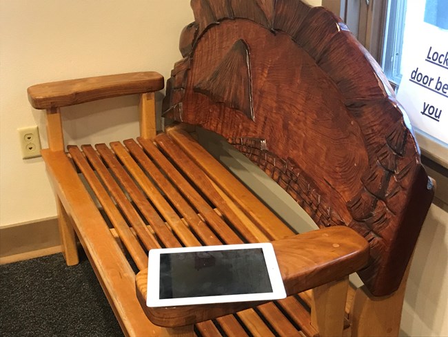 I-pad sitting on wooden bench left by unknown owner.