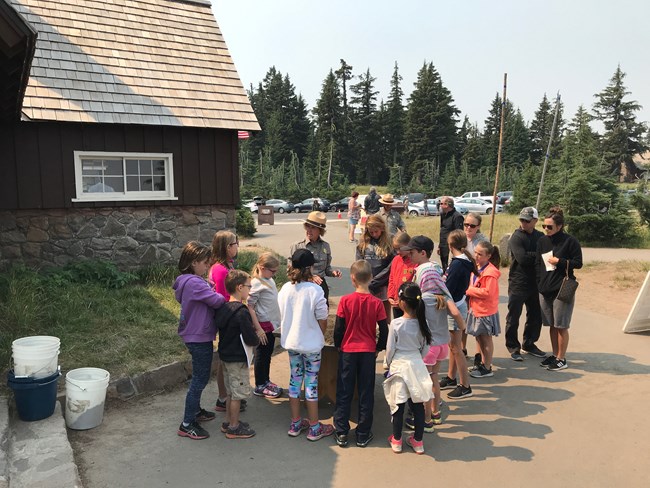 Many Junior Rangers standing with a Park Ranger