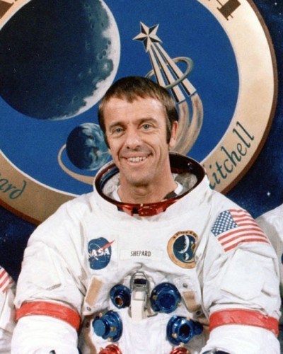portrait of a man wearing a white spacesuit with the American flag and NASA emblem