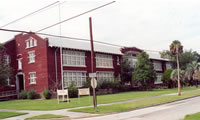  <two photo series> Parking Compatible with the Historic Character. The proposed conversion of this school to apartments involves adding more on-site parking.  Most of the parking (shown on the site plan) for the rehabilitation project will be accommodated in existing rear and side locations. However, some additional parking is required. To satisfy that requirement and yet preserve the integrity of the intact front lawn, spaces for angled parking are proposed at the perimeter of the front lawn immediately adjacent to the street. This solution is successful, as the peripheral parking is unobtrusive and will preserve the main expanse of front lawn, which is a significant landscape feature. Photo/Drawing: NPS files