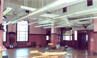 <two photo series> Incompatible treatment of an Interior Space. The two-story height--as well as the arched windows and trim--make the mail-sorting room in this historic Post Office considerably more significant than most utilitarian spaces (shown). Dividing the two-story space by inserting a full floor during rehabilitation (shown) altered the distinctive character-defining volume of this space and resulted in denial of certification of the project. Photo: NPS files