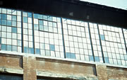 The heavier frame (shown) of the pivot sash in this historic industrial building creates a distinctive pattern in the overall grid of muntins. This visual distinction can clearly be reproduced in any replacement window, regardless of how or whether the                     window operates. Photo: NPS files