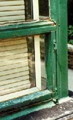 This shows an exterior steel window unit in an advanced state of decay.