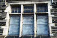 This detail shows the building's dirty stonework and deteriorated window sash before rehabilitation project work.