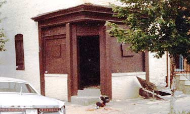 A mid-nineteenth century corner grocery store, with a traditional owner's residence above, was located in a historic district of mixed commercial and residential use. The historic storefront had retained its original corner entrance and flanking plate glass windows. The base, however, had been bricked in and the plate glass was boarded over. Photos: NPS files.