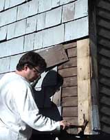 Removal of existing siding, preparatory to restoration of historic siding