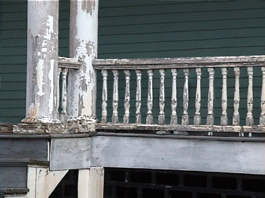 porch rail exhibiting paint deterioration