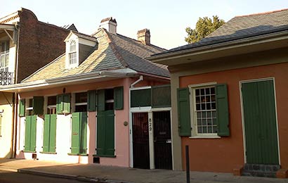 One-story houses with shutters closed over their windows.