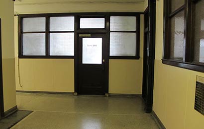 Corridor with windows glazed with obscure glass in the walls and the doors.