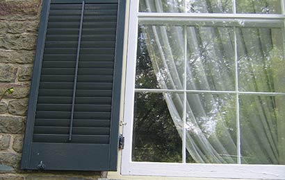 Close-up view of exterior storm windows and shutters that are in good condition.