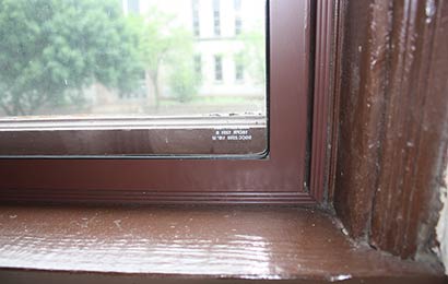 Close-up of an interior storm window placed within a window opening and matching the window in color.