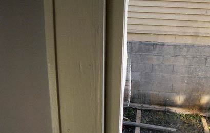 Detail of a plaster wall, wood window trim, and a wood window showing their relationship to each other.