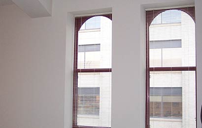 Two windows surrounded by deep recesses created by furring-out walls.
